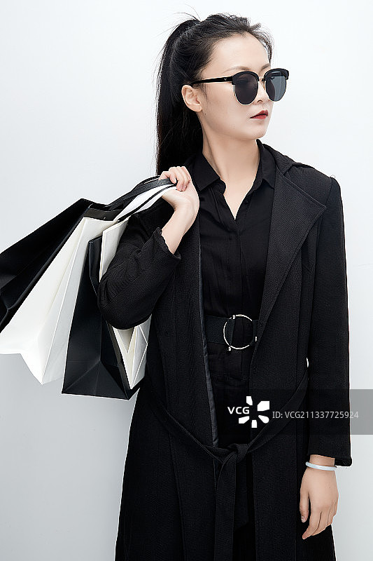 白色背景下手提购物袋时尚美丽的亚洲少女图片素材