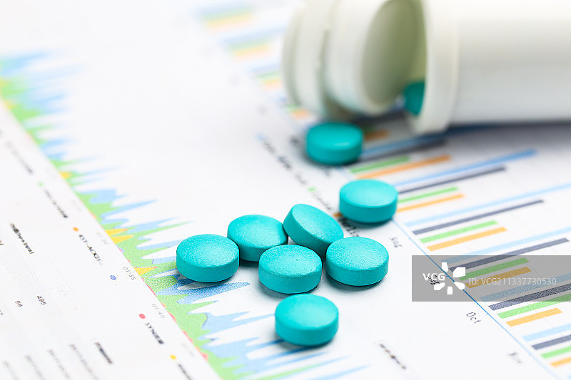 蓝色药片放在统计表背景上图片素材
