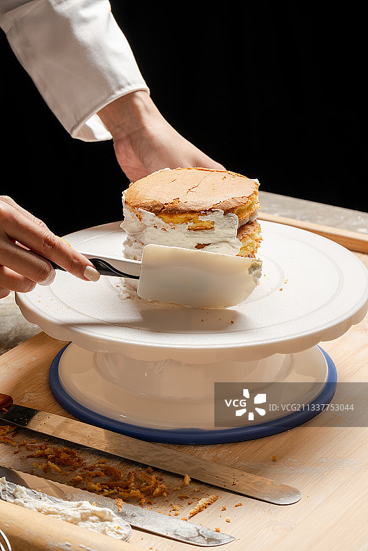 在蛋糕坯子上抹奶油图片素材