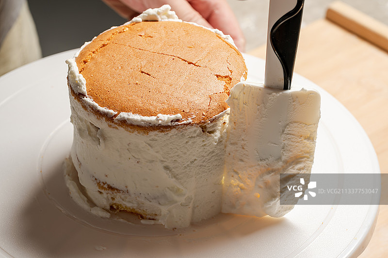 在蛋糕坯子上抹奶油图片素材