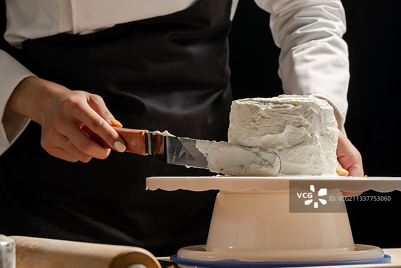 在蛋糕坯子上抹奶油图片素材