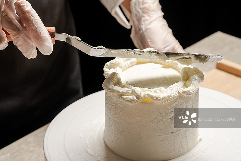 在蛋糕坯子上抹奶油图片素材