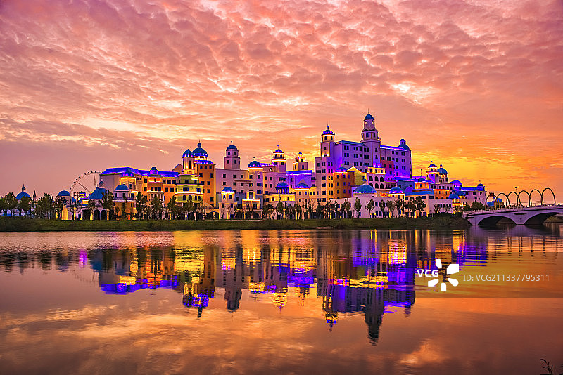 晚霞中的湖南常德柳叶湖畔卡乐星球欢乐城和水中毒倒影图片素材