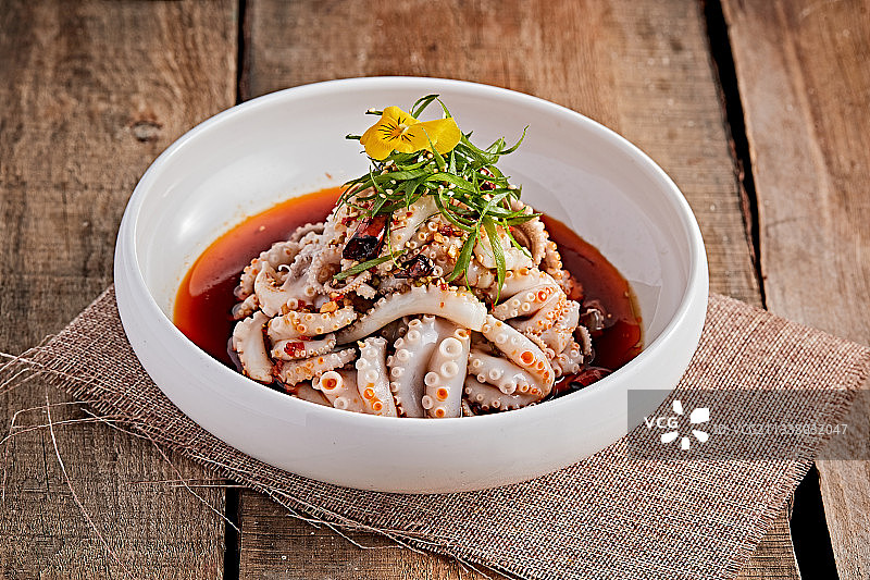 白色瓷盘装的红油醋腌章鱼爪图片素材