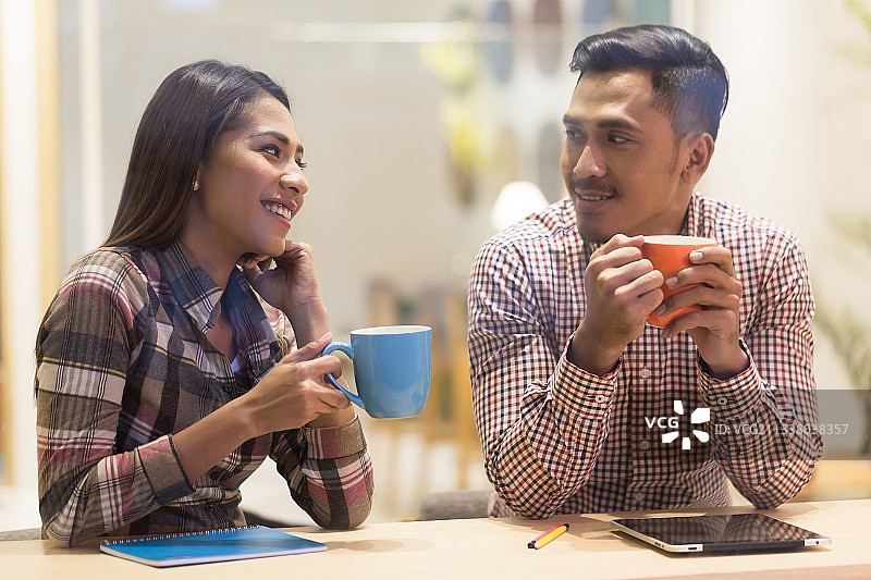 一群意志坚定的亚洲年轻人和一群在办公室一起工作时使用平板电脑的女性图片素材