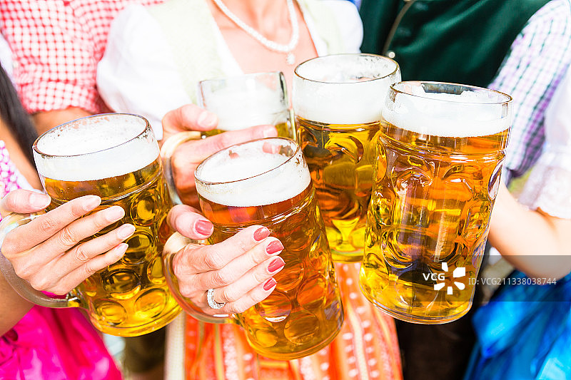 在巴伐利亚啤酒花园与啤酒碰杯，近距离五啤酒杯图片素材