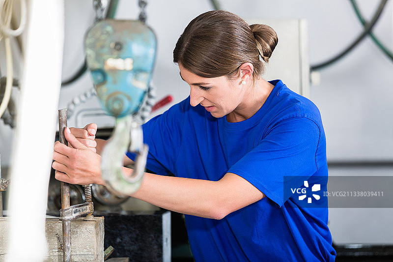 女石匠在抛光机中调整工件图片素材