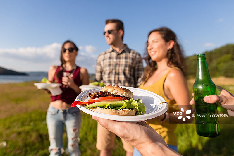 一群朋友，典型的夏季烧烤派对，汉堡和啤酒图片素材