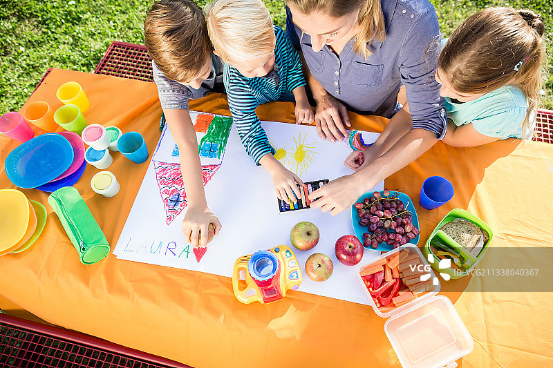 男女学生在吃水果和三明治的午餐休息时间画画图片素材
