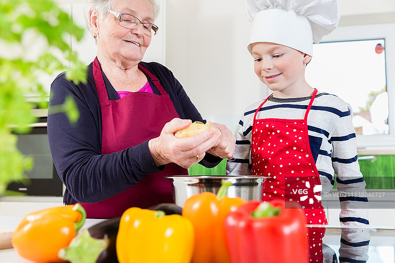 快乐的奶奶和她的孙子一起做饭图片素材