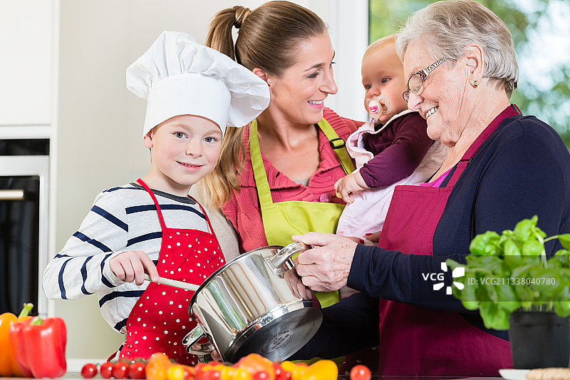妈妈，爸爸，奶奶和孙子一起在厨房准备健康的食物图片素材