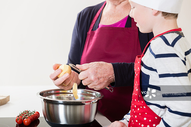 奶奶和孙子在家里的厨房里一起做饭图片素材