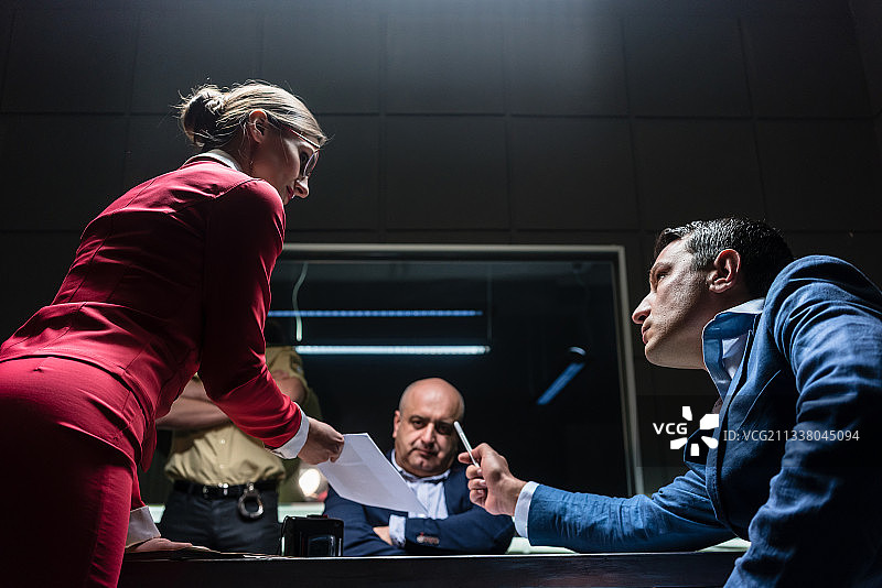 低角度视角的女律师与公诉人意见不一致，在预审期间不情愿地在某派出所办公室对嫌疑人进行审讯图片素材