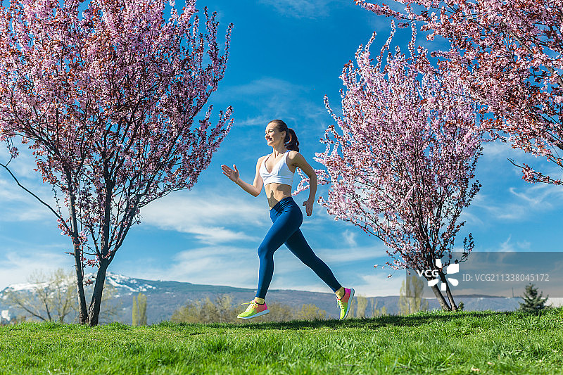 一个在阳光明媚的春日跑步的女人图片素材