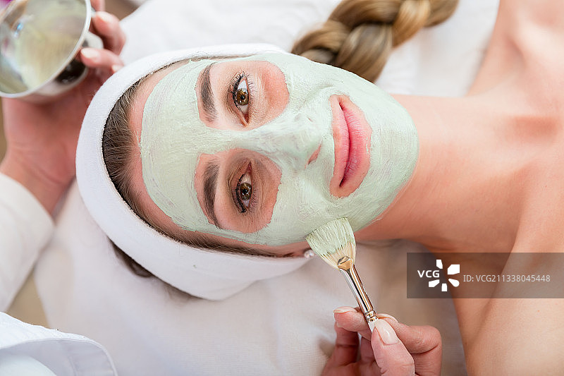 微笑的女人正在美容院做面部护理图片素材