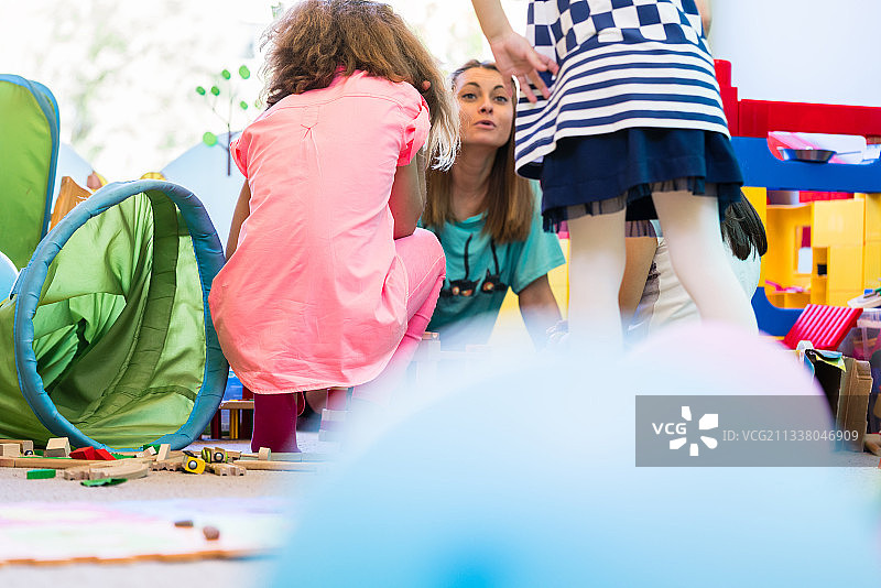 年轻敬业的幼儿园老师在课堂上为孩子们协调一个有趣的活动图片素材