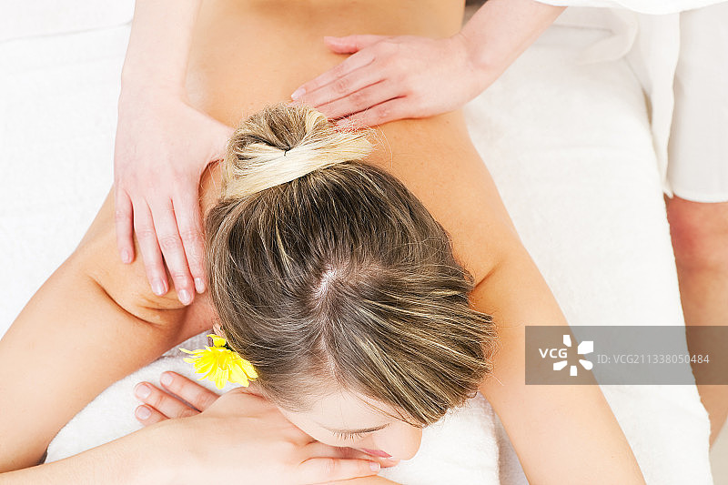 美丽的女人正在享受健康背部按摩而且感觉很好图片素材