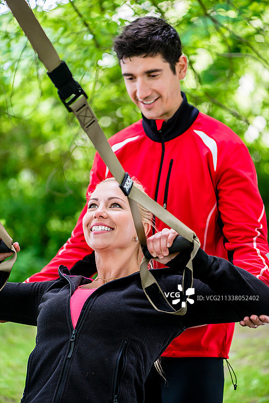 运动女人与教练在吊索训练图片素材