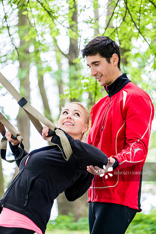 运动女人与教练在吊索训练图片素材