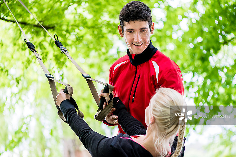 运动女人与教练在吊索训练图片素材