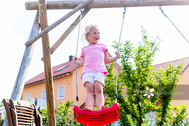 小女孩在屋前荡秋千图片素材