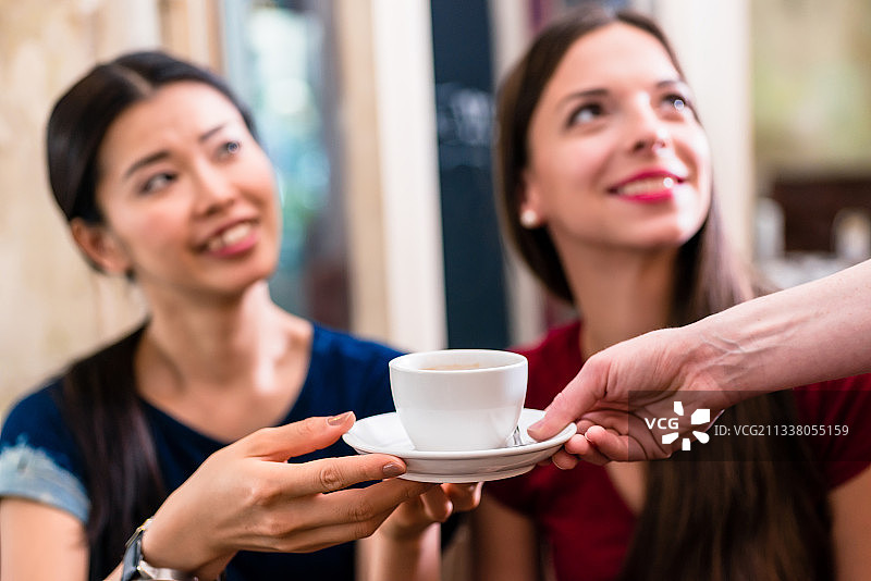 白咖啡在室内招待年轻女顾客图片素材