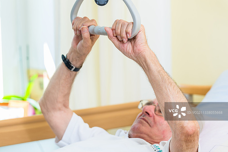 在疗养院里，老人抓着把手想要下床图片素材