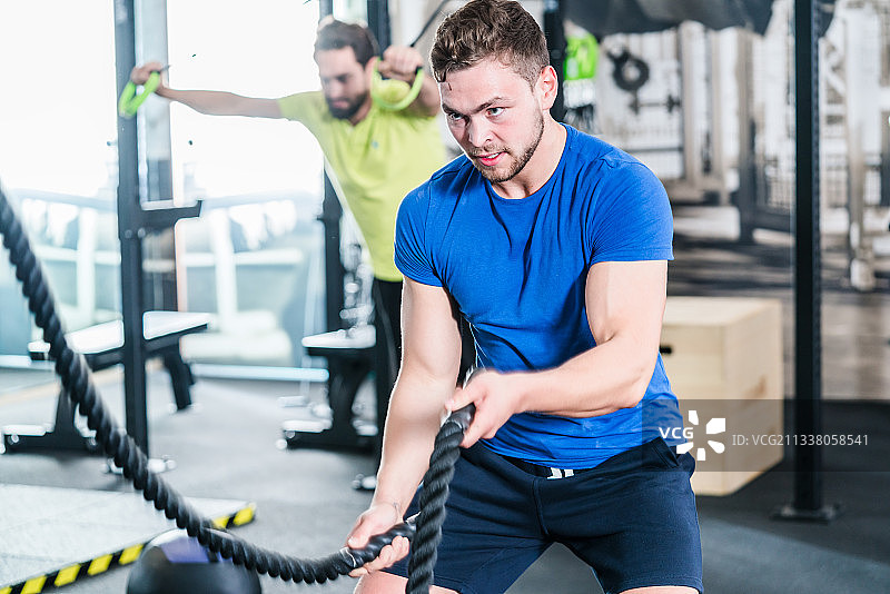 人们在健身房用格斗绳进行功能性健身训练图片素材