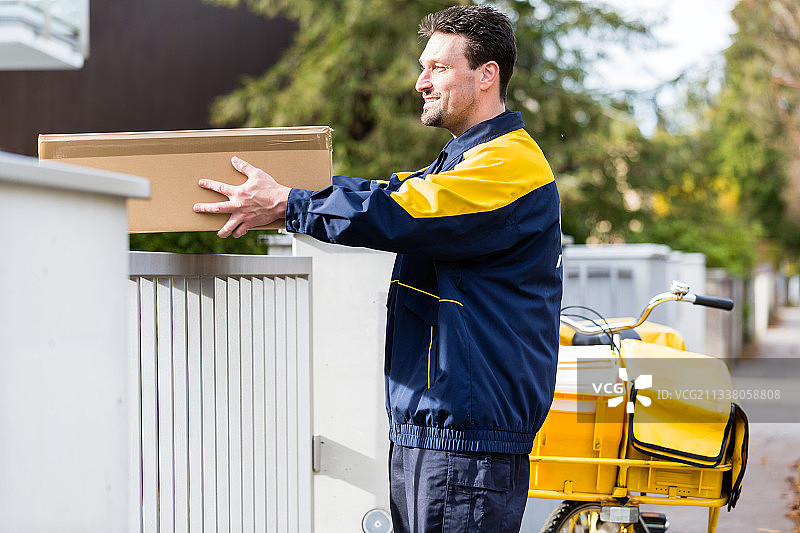 邮递员送包裹成礼物的邮包图片素材