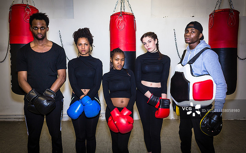 四个年轻坚定的拳击手和他们的经验丰富的拳击教练看着镜头的肖像图片素材
