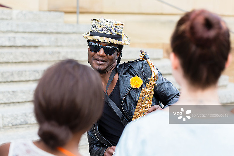 黑街音乐家戴着太阳镜和萨克斯管做音乐图片素材