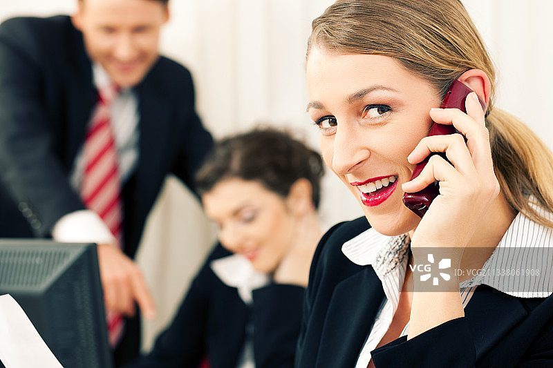 在办公室用手机和电脑工作的小型企业团队图片素材