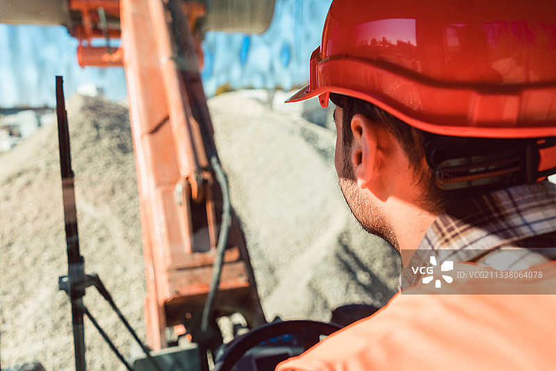 在建筑工地上辛勤操作装载机的工人图片素材