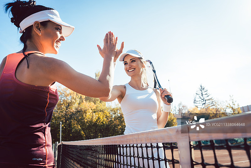 女子在一场友好的网球比赛后击掌庆祝图片素材