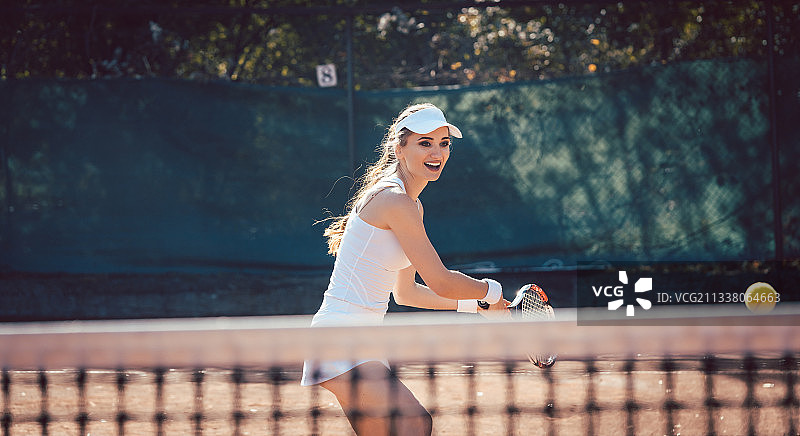 在球场上用力打网球的女人图片素材