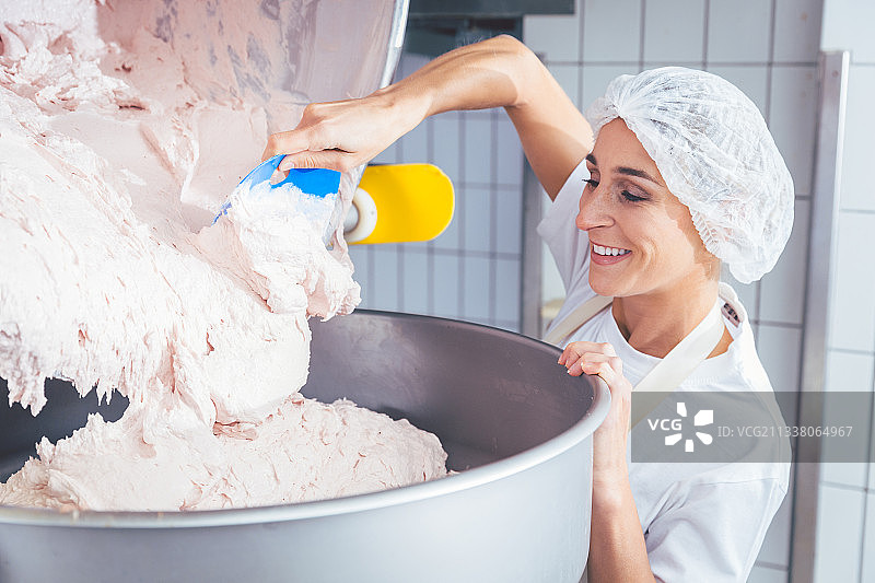 在屠宰场工作的妇女，制作肉糜检查质量图片素材