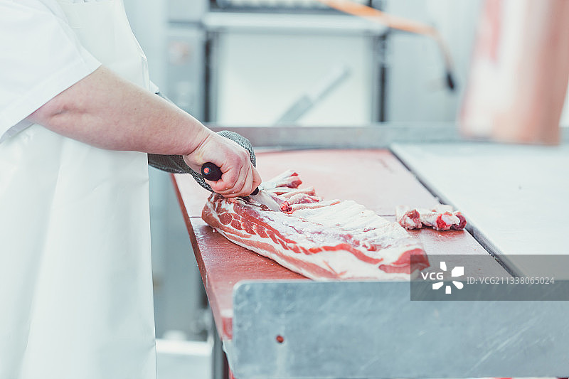 屠夫在屠宰时用刀切肉作进一步加工图片素材