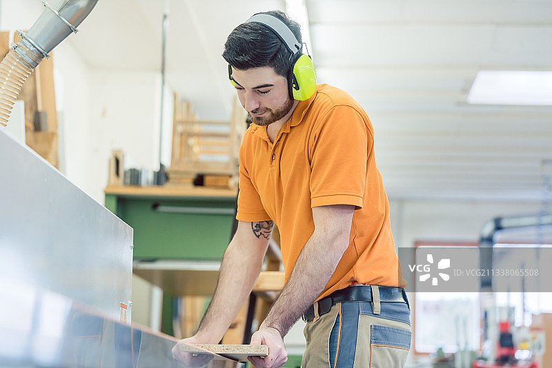 在家具厂用电脑控制的机器工作的木匠图片素材