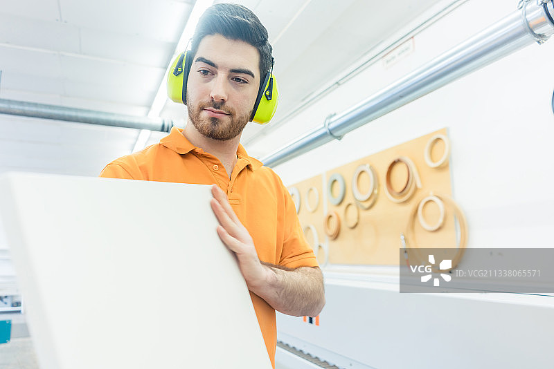 家具厂的木匠在单板机器上勤奋工作图片素材