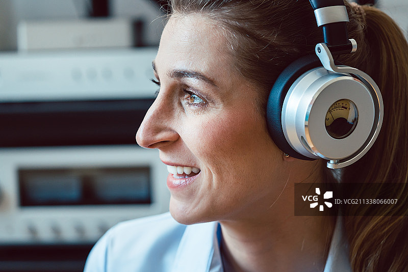 女人戴着耳机听音乐，享受着声音图片素材