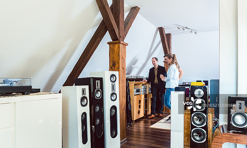 一对夫妇在Hi-Fi商店买新的家庭音响，售货员在等着图片素材