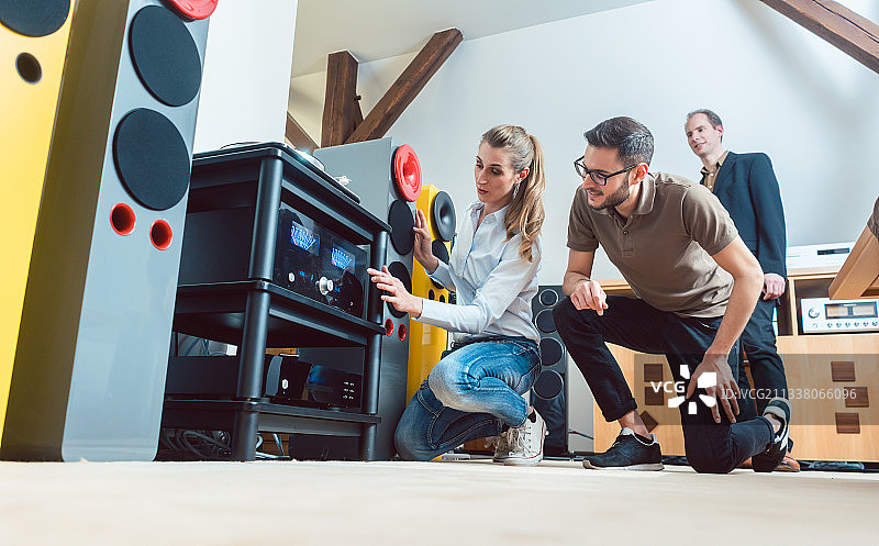 年轻夫妇，男女，在商店里购买高端音响设备图片素材