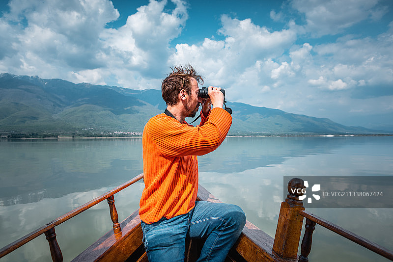 人在船上观鸟，湖四面环山图片素材
