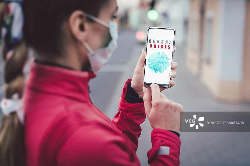 一名妇女用手机阅读有关covid-19危机的新闻图片素材