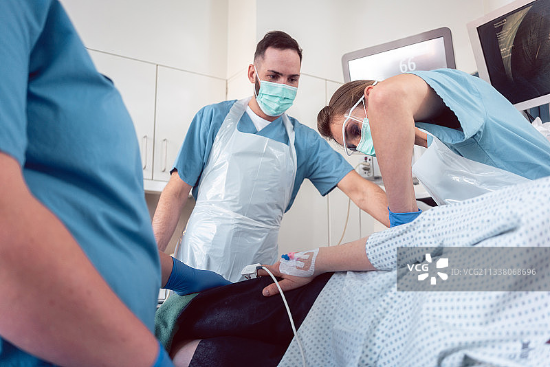 在医院给镇静病人做结肠镜检查的外科医生图片素材