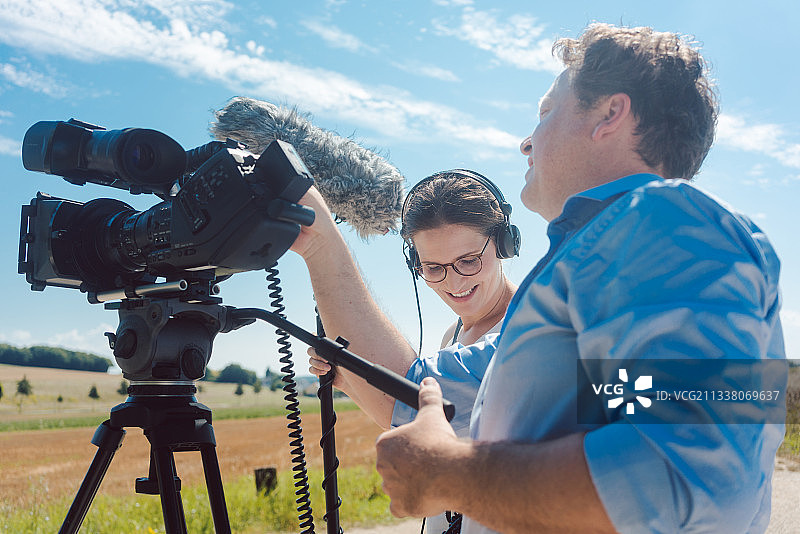 摄影师带着他的相机和助手在片场操作他的小工具图片素材
