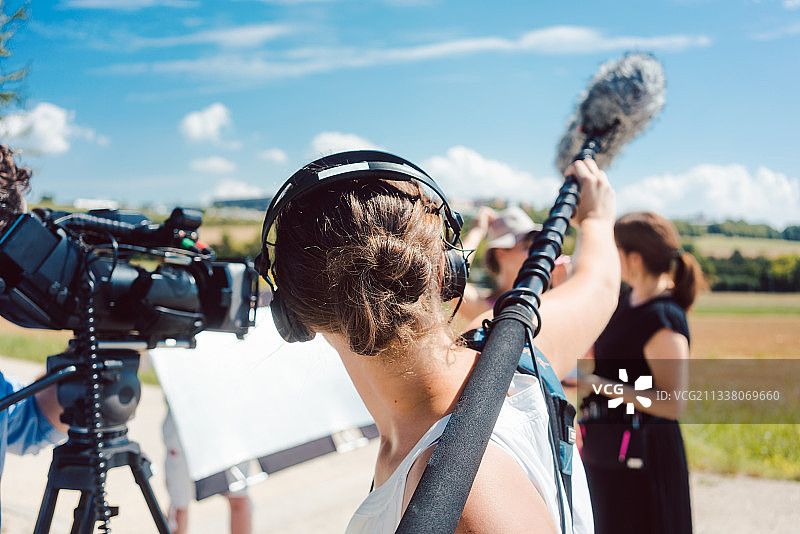 在视频制作过程中捕捉音频，手持麦克风的妇女图片素材