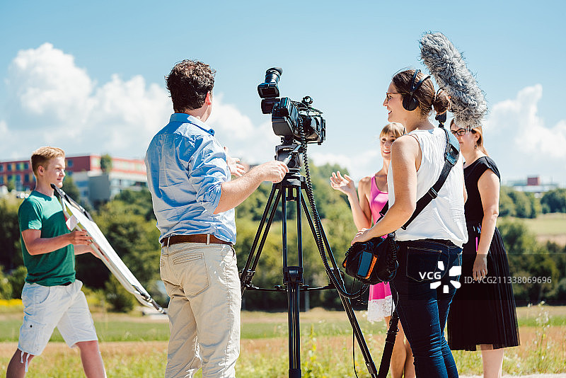 模特在化妆期间的视频拍摄与摄像机和音响工程师在准备图片素材