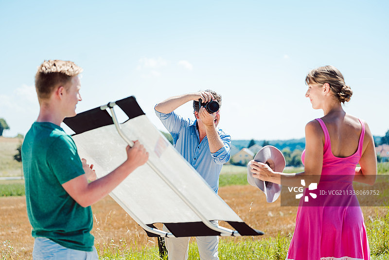 摄影师，模特和助理在拍摄期间在片场工作图片素材