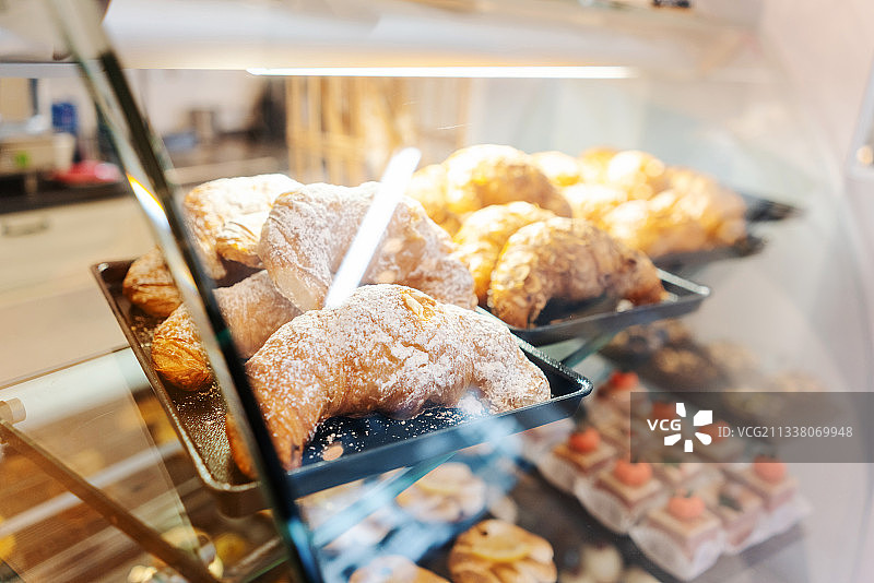 一个卖糖果的女人从她店里的玻璃橱窗里射了出去图片素材